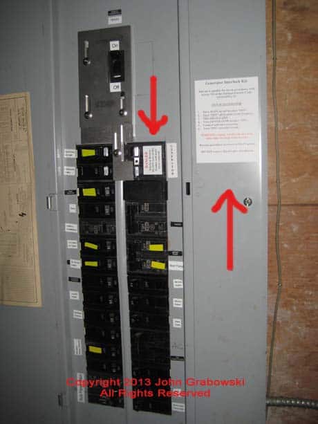 The completed interlock kit installation with red arrows pointing to labels that were provided by the interlock kit manufacturer