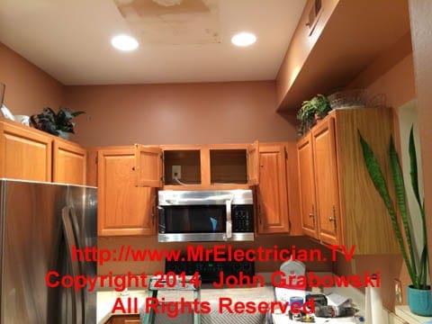 Microwave oven installed under a kitchen cabinet.