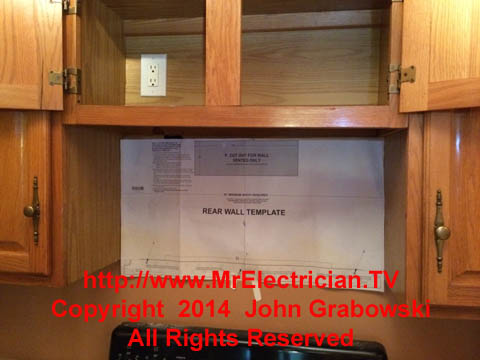 Microwave oven mounting template mounted to the wall under the kitchen cabinet