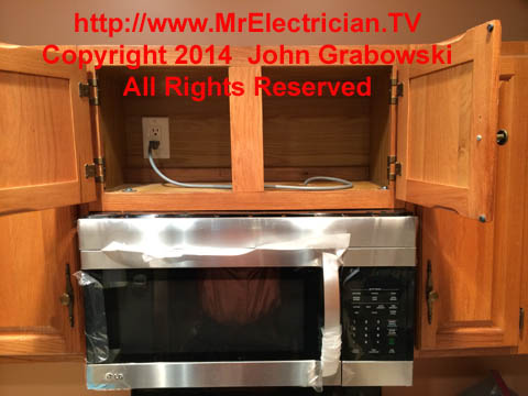 Over-the-range microwave oven mounted under the kitchen cabinet above the stove