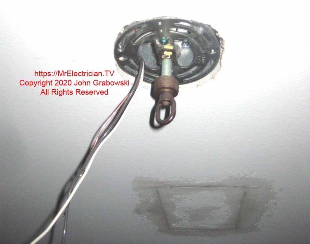 Light fixture ceiling hook attached to the ceiling box next to patched hole