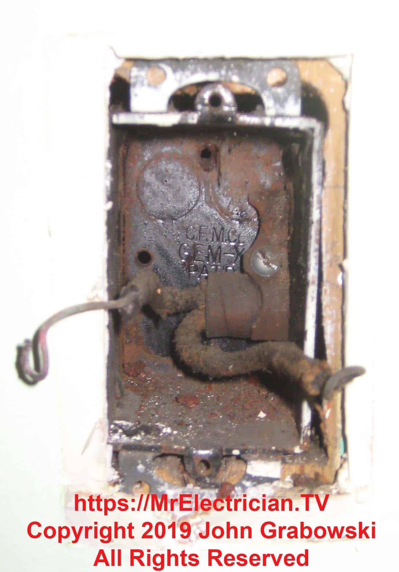 Very old metal electrical receptacle outlet box in the wall with an old BX cable inside
