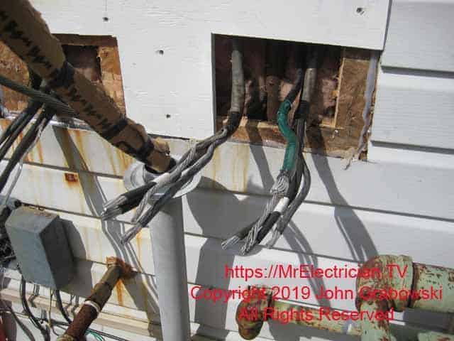 The existing tenant load wires and the grounding conductor to the water pipe are sticking out of the wall