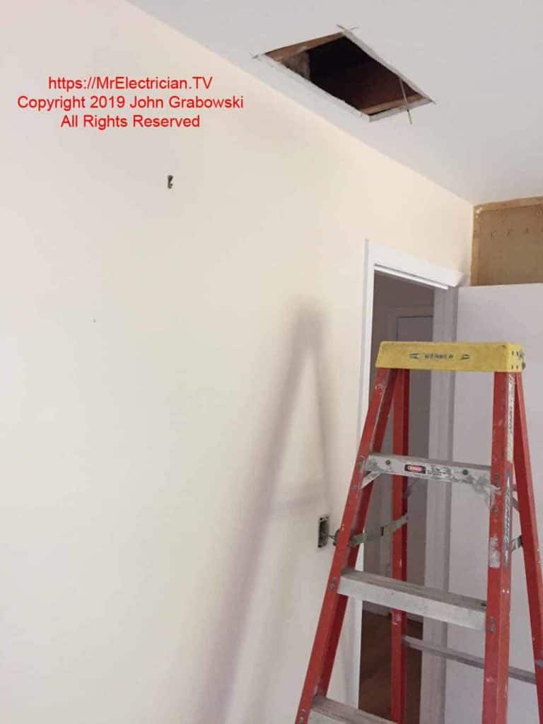 It was necessary to cut an access hole into the attic space to facilitate the installation of a new 14/3 cable from the existing wall switch location to the center of the room so a new switch could be added.