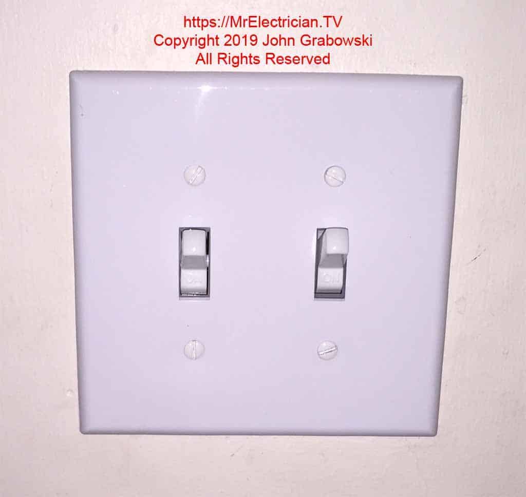 The two new wall switches are finished with a mid-size wall plate. You cannot tell that one switch was added to the existing by this photo.