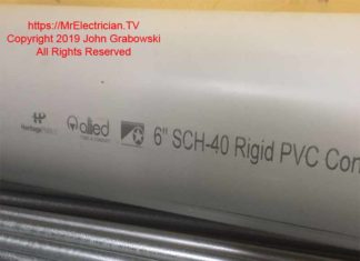 Photo of a short piece of six inch PVC schedule forty electrical conduit sitting on a bundle of half inch EMT conduit