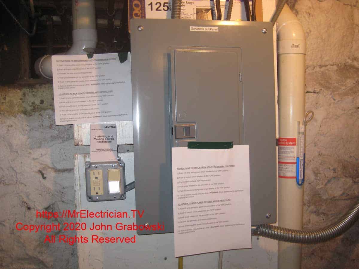 A completed generator sub-panel with a Square D generator interlock between the main circuit breaker and the generator circuit breaker with written instructions on how to operate it posted on the sub-panel cover door