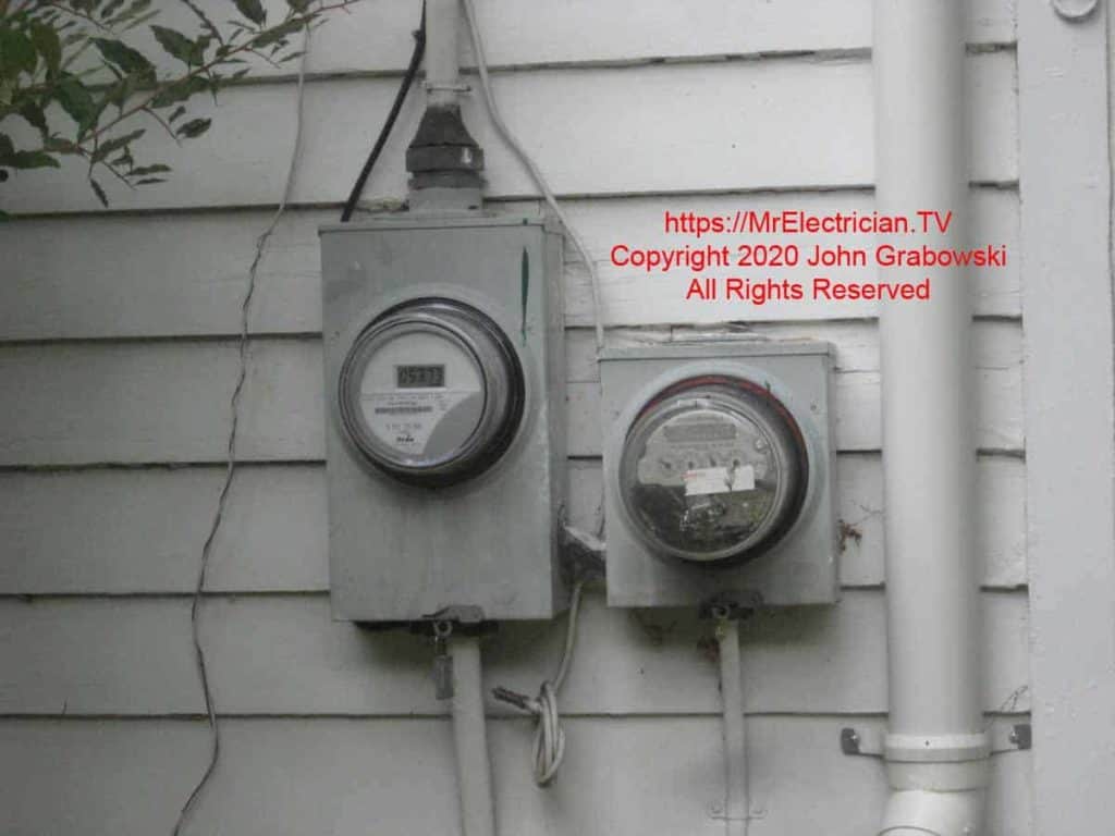 Two electric meters for a one family house mounted on wood clapboard siding with one meter fed from the other meter. The second meter was for the electric water heater.