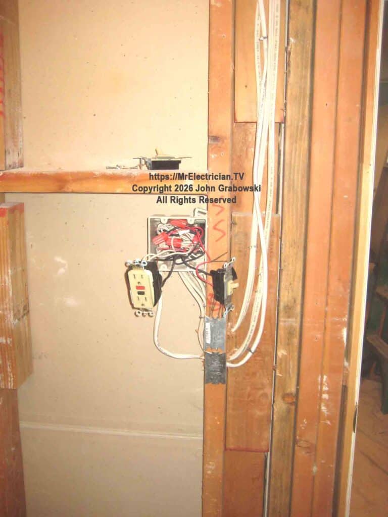 A closer image of the bathroom switch wiring changes. Note the addition of the steel safety plates to prevent nails from penetrating the wires. 