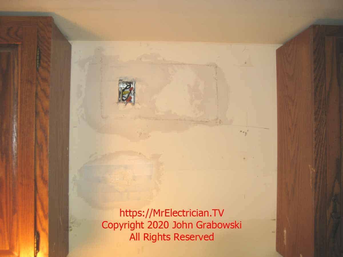 Patched holes from installing the electrical outlet for powering the microwave oven