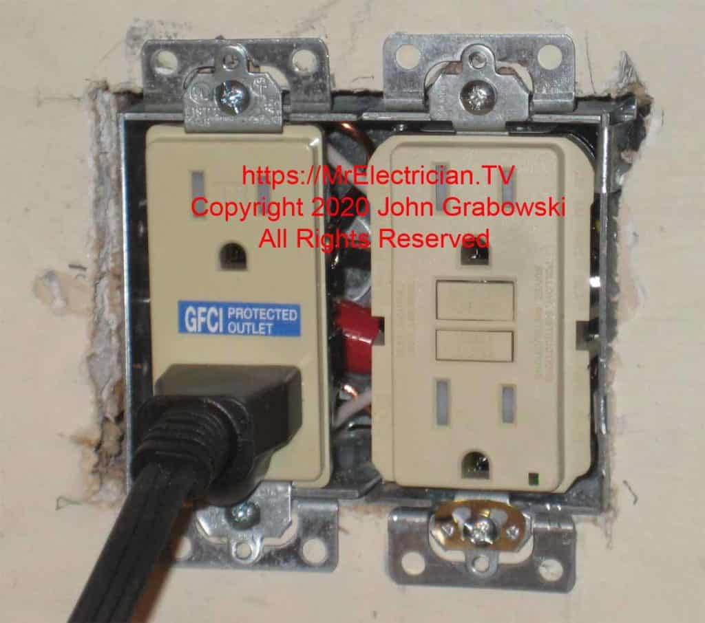 Two gang electrical receptacle box with a GFCI outlet and a GFCI protected outlet. The ears on the outlets have been removed
