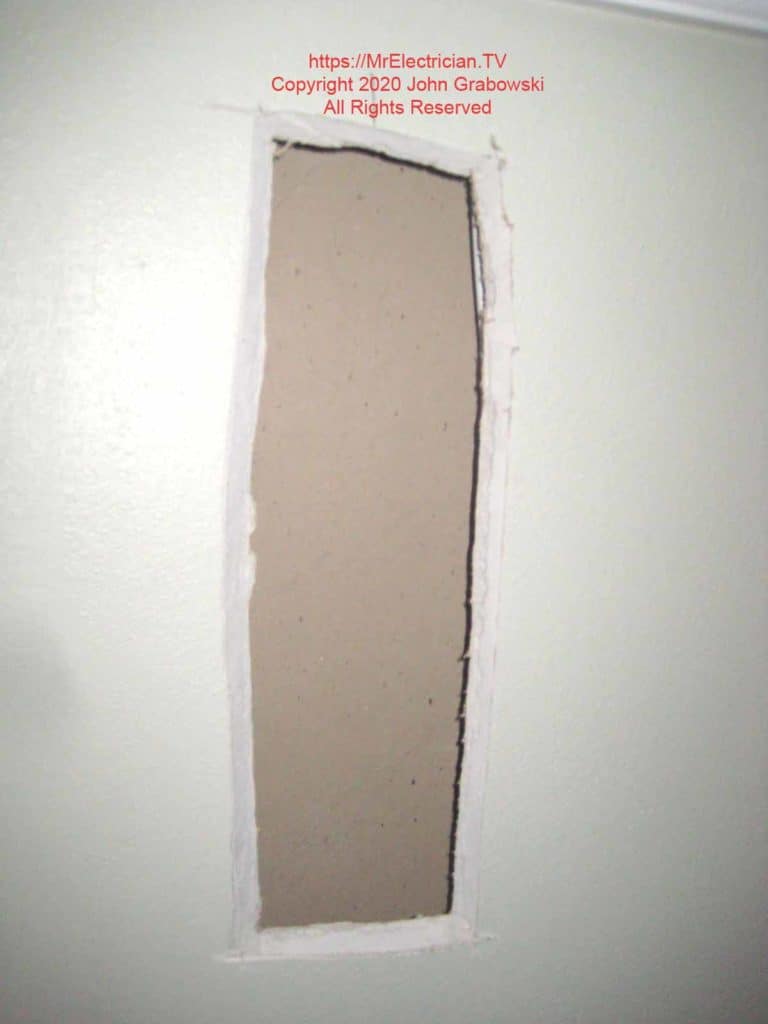 An access hole cut at a 45-degree angle was needed for the wiring to add a dimmer switch and a new ceiling light fixture.