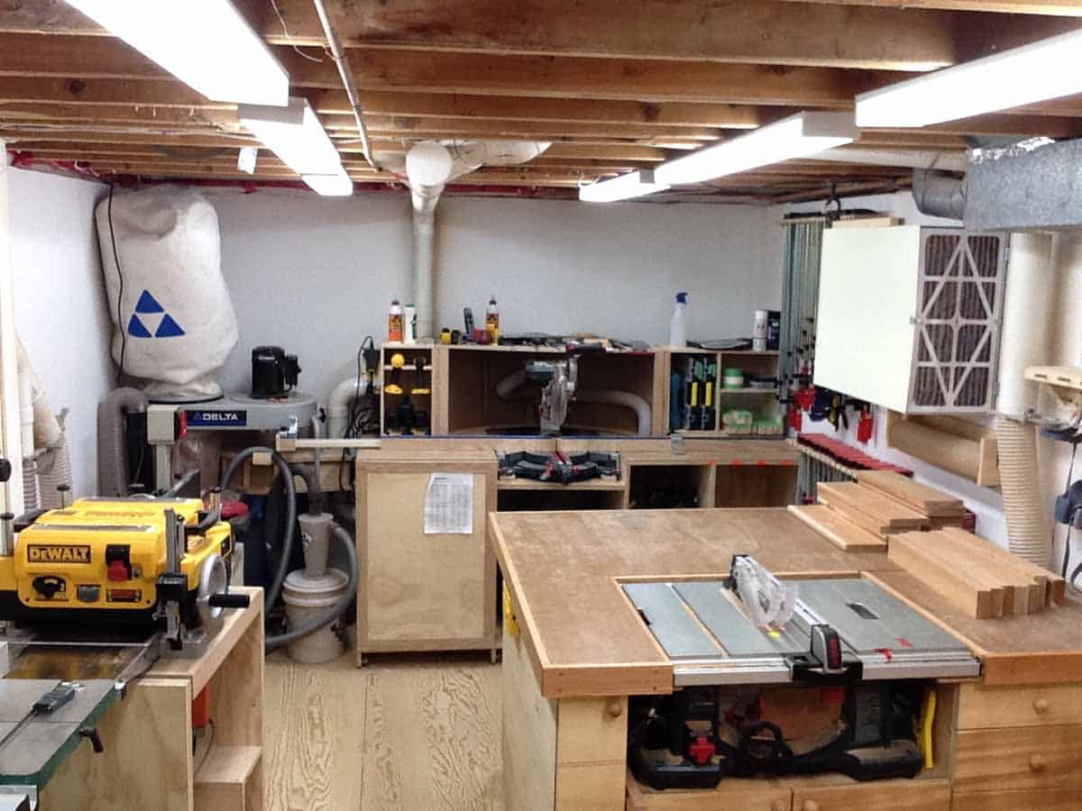 A small cellar housing a functioning wood shop with wood working tools