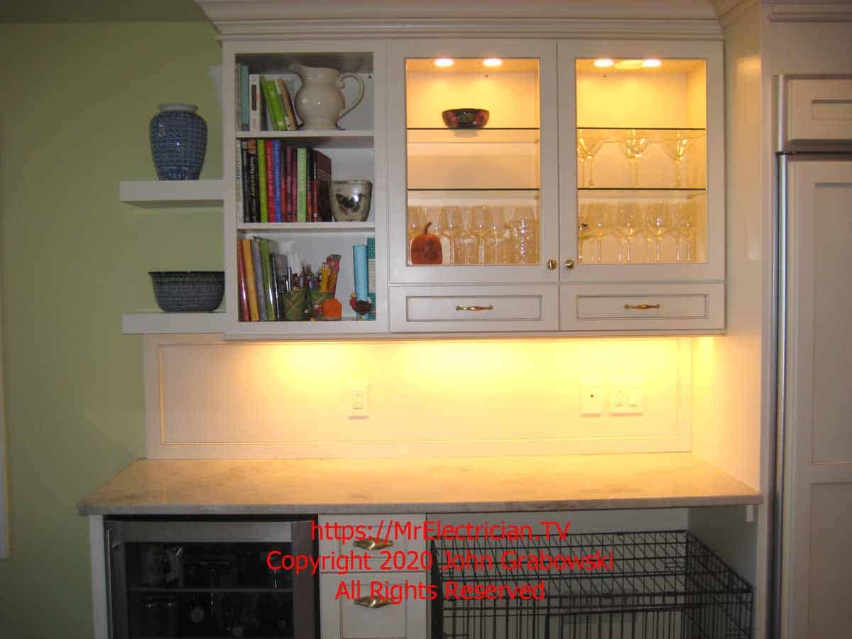 Finished kitchen cabinets with low voltage recessed lights inside and line voltage under cabinet lights