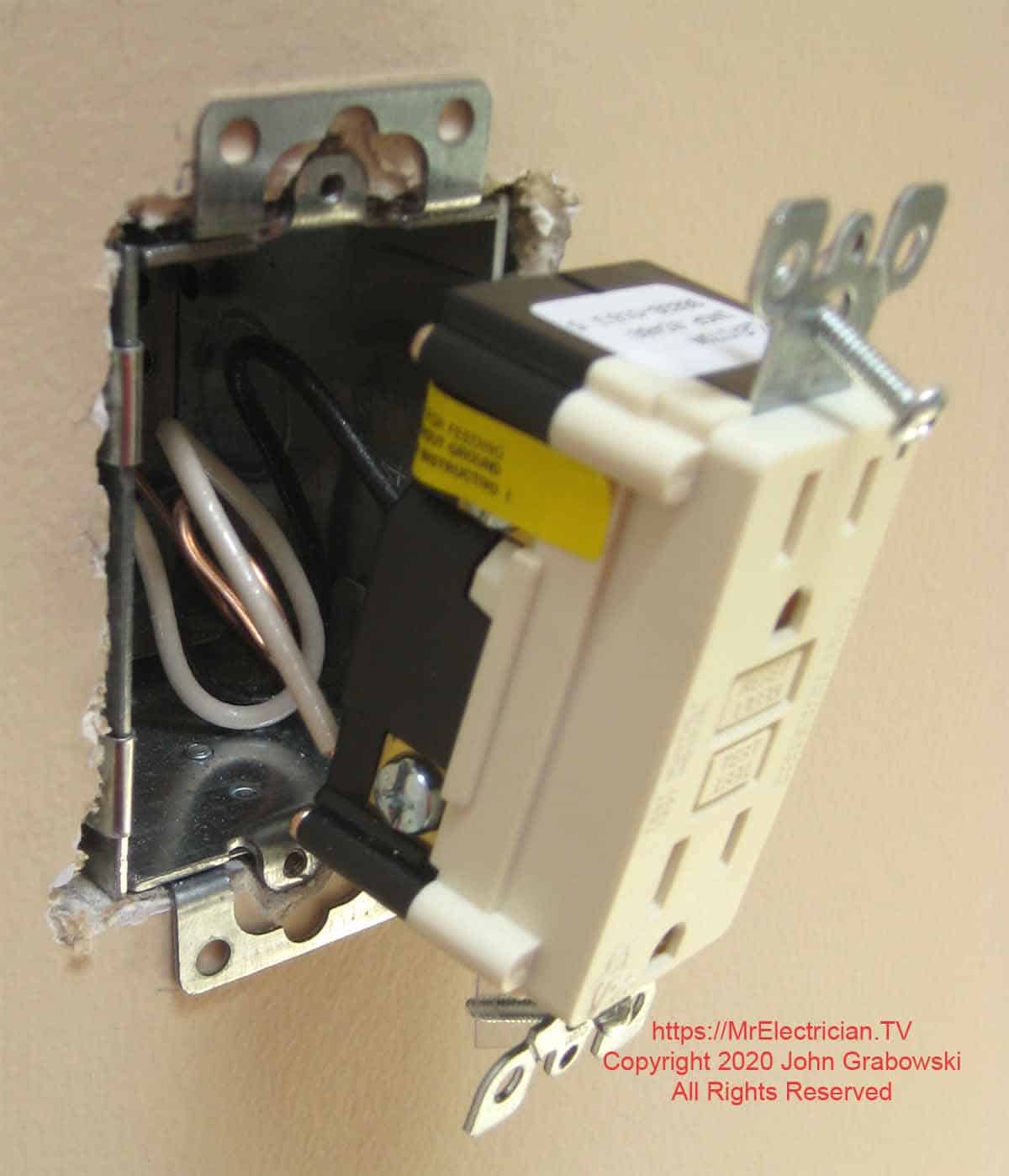 GFCI outlet ready for insertion into electrical box in the wall