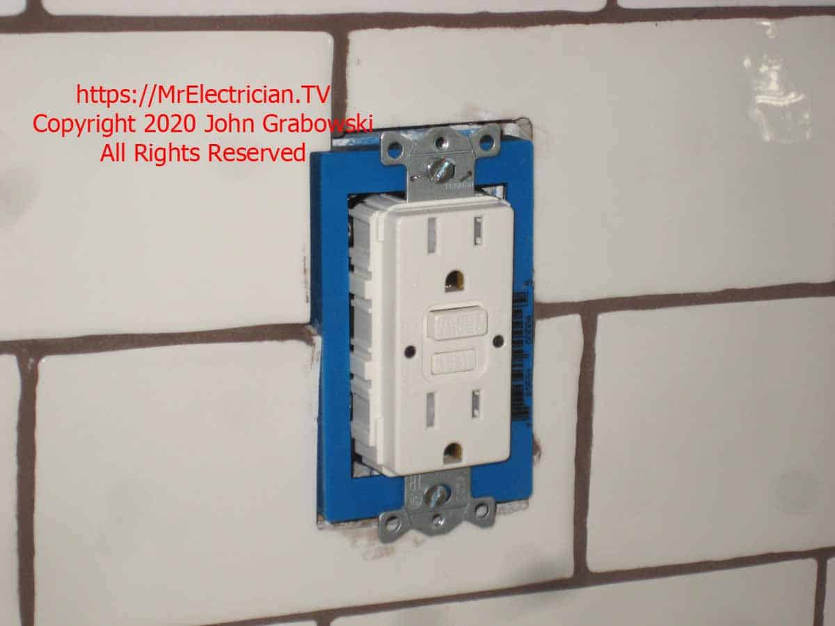 GFCI outlet mounted to the ceramic tile back splash using a one-gang, 1/2" ReceptXtender receptacle box extender for support.