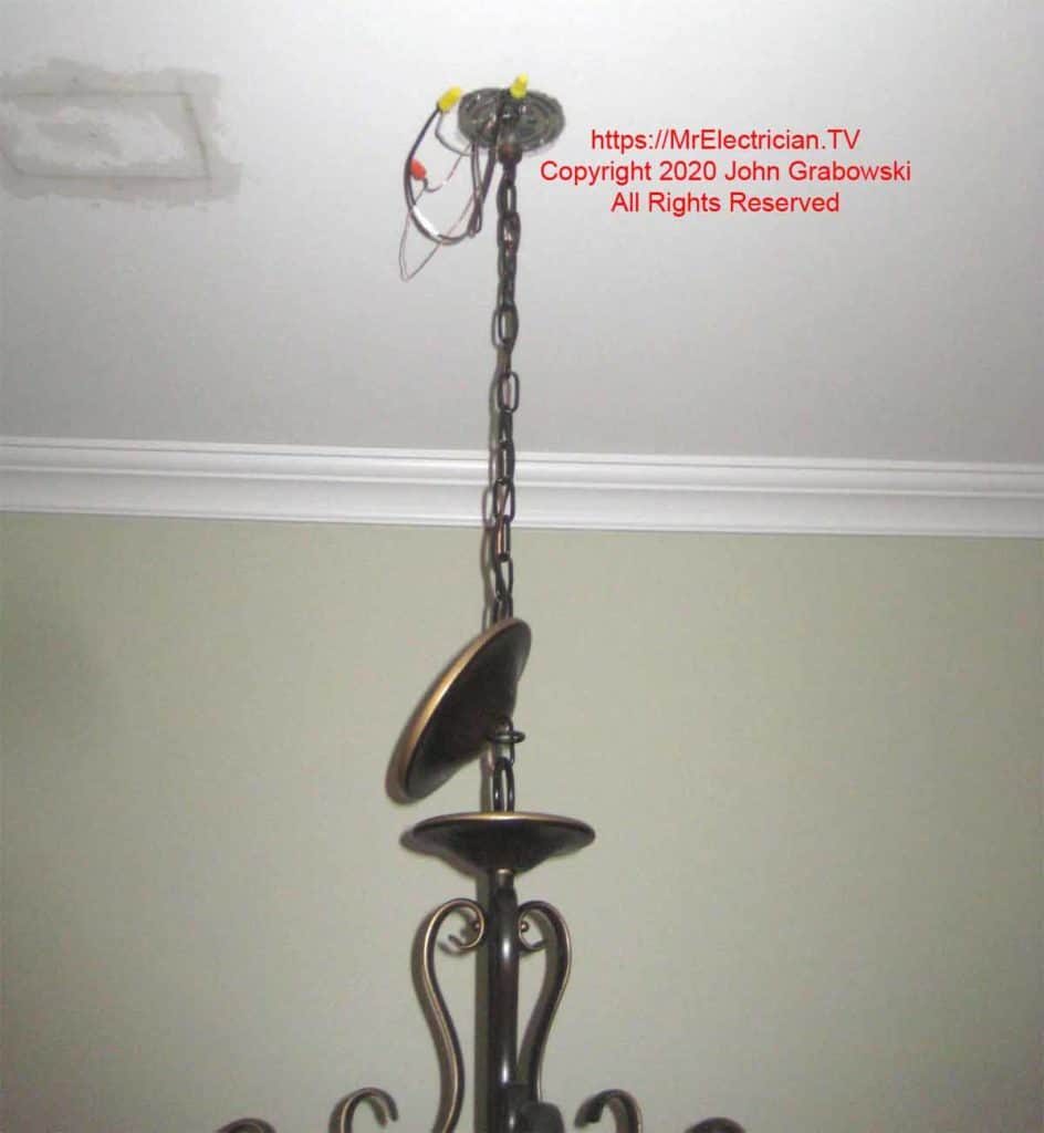 Ceiling fixture hanging by a chain with the wires connected, but canopy not installed