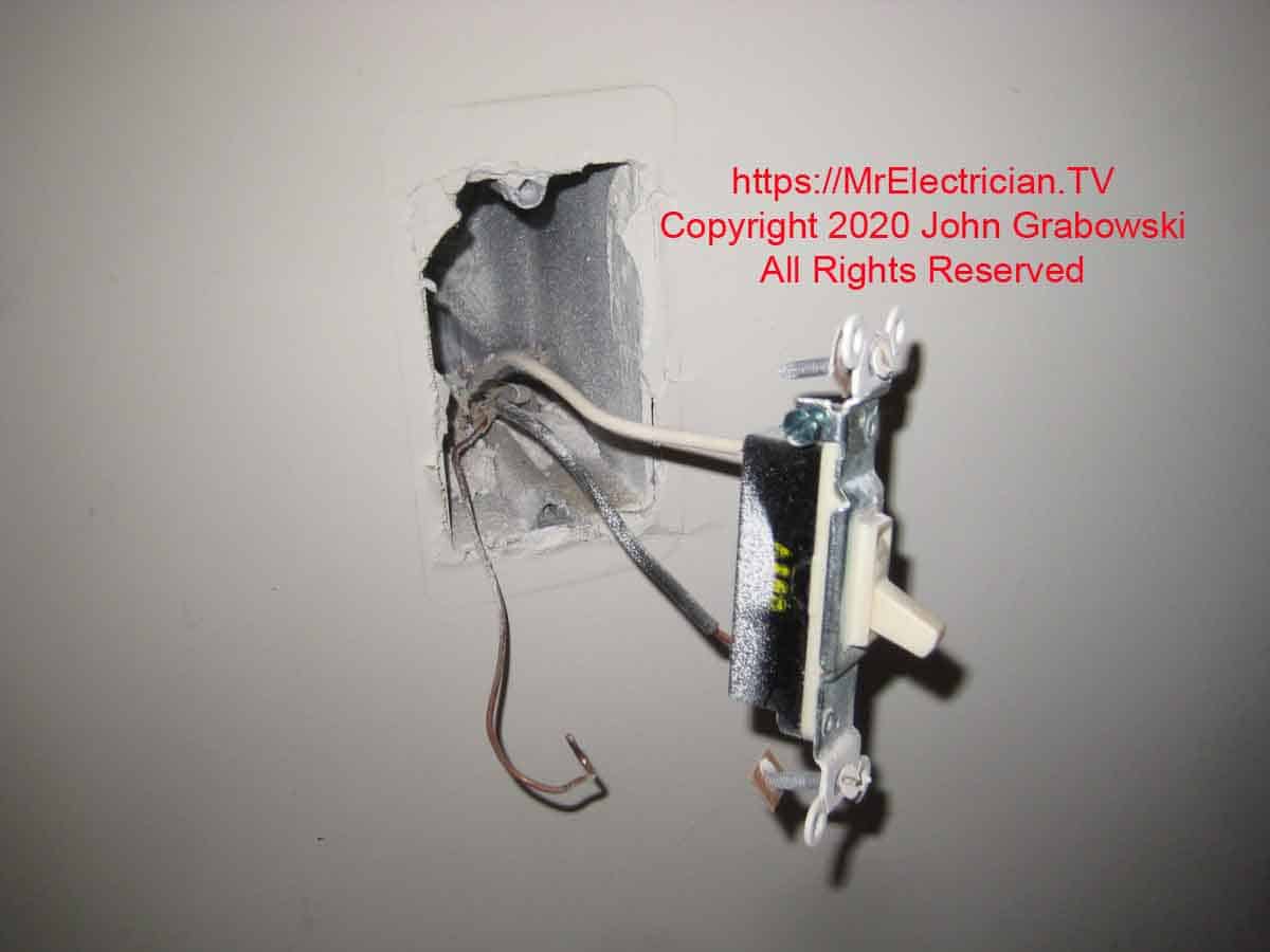 Old wall switch still wired and pulled out from wall