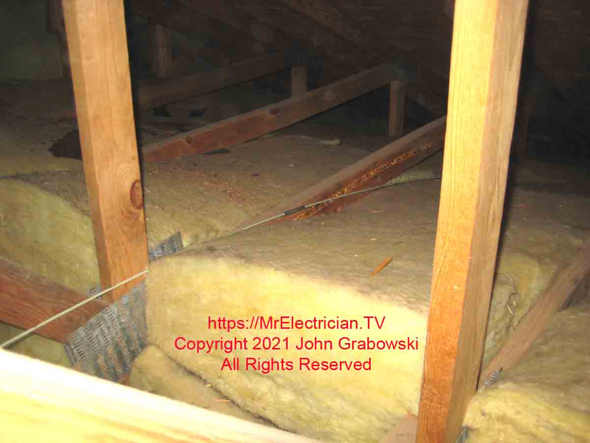 Fiberglass wire fishing rod resting on top of attic insulation