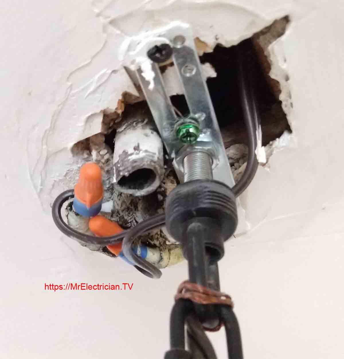 Light fixture wrongly installed with very old wiring without an electrical box in the ceiling