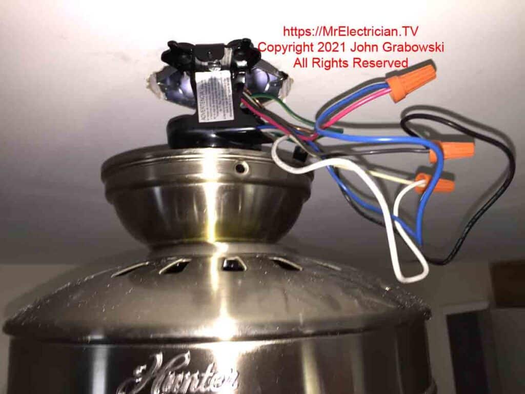 A photo of the electrical connections for a ceiling fan while the canopy cover is down and the fan is hanging by the short rod. CLICK THE IMAGE to see fans on Amazon.