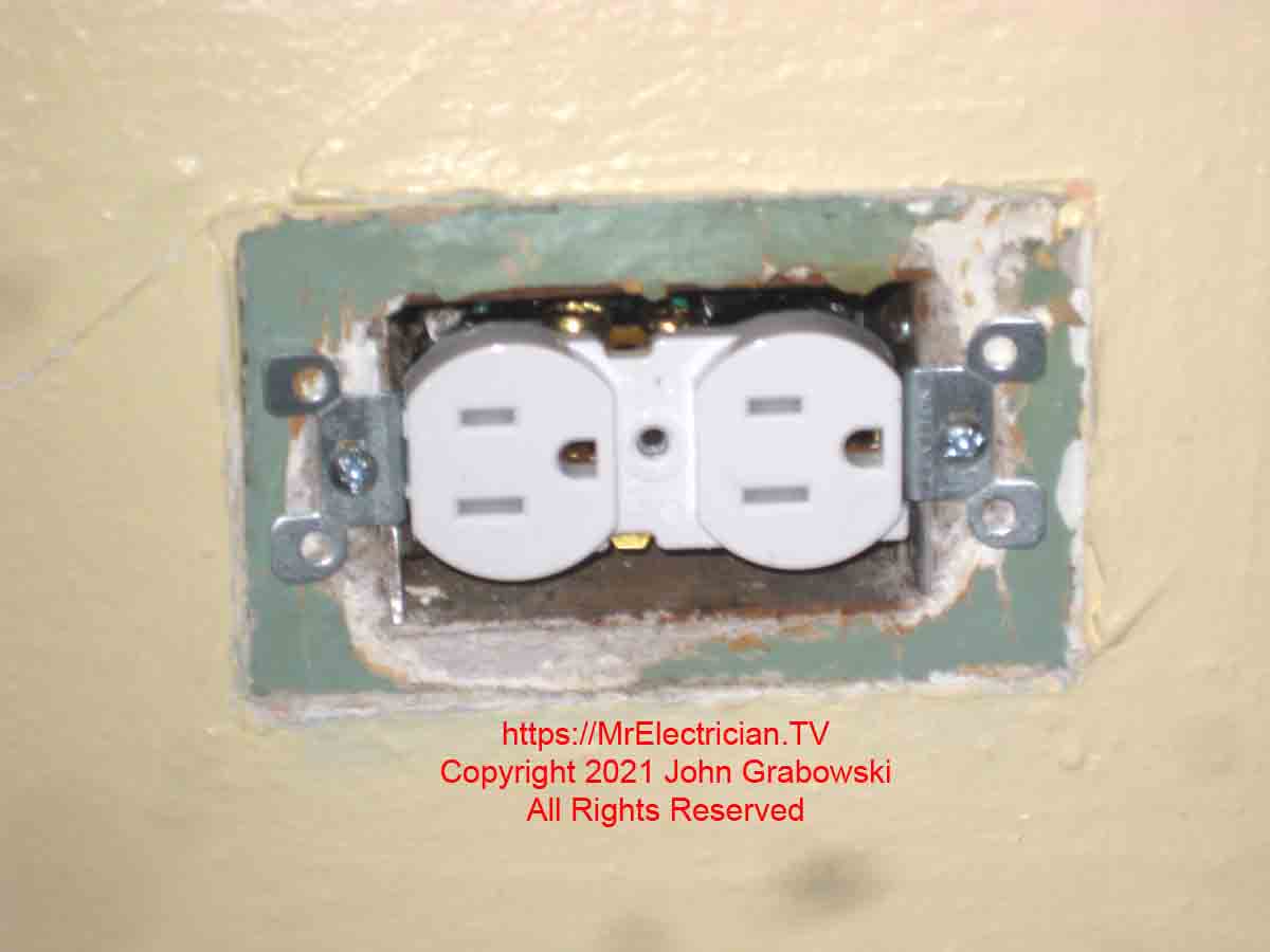 A new tamper-resistant three-prong electrical outlet installed to replace a two-prong ungrounded outlet