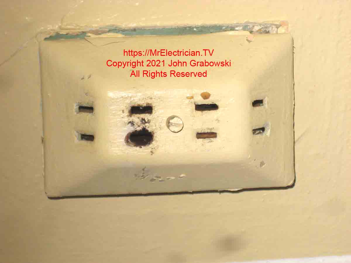 An old multi-outlet extension with a burned hole
