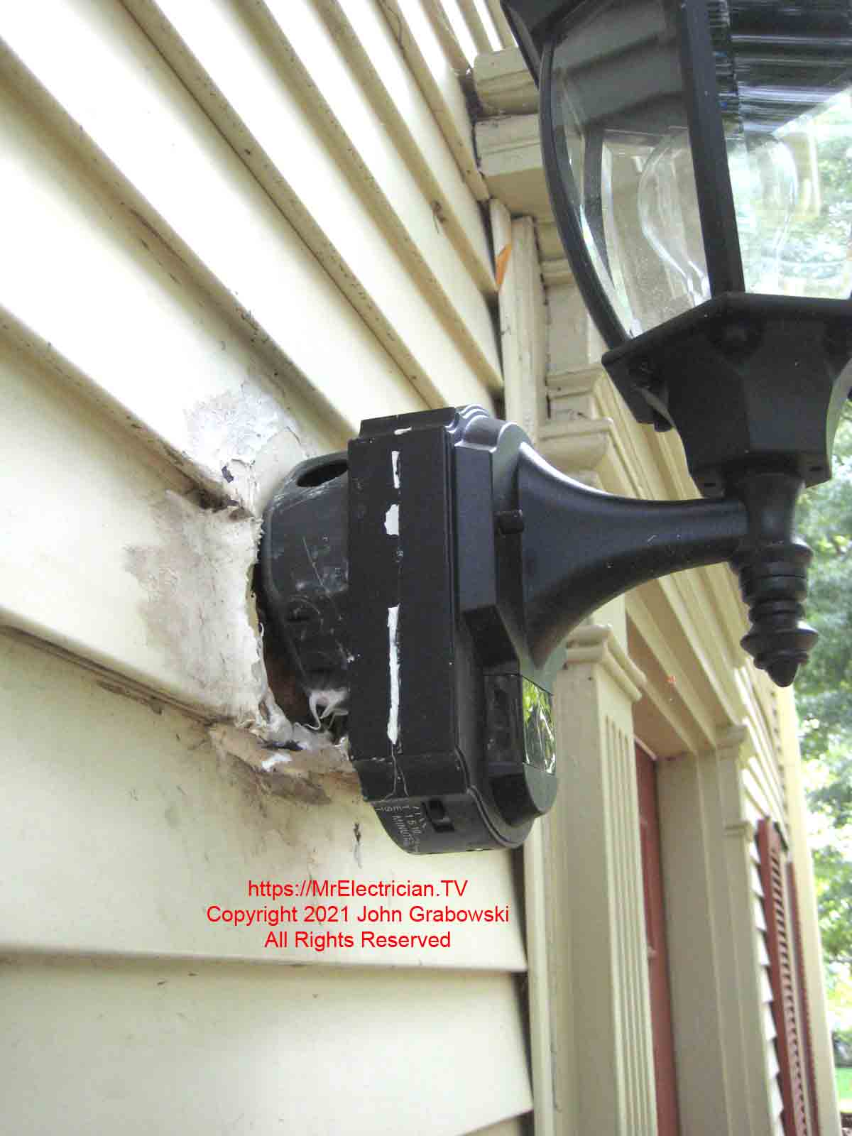 Side view of an outdoor light fixture mounted to a surface mounted indoor electrical box