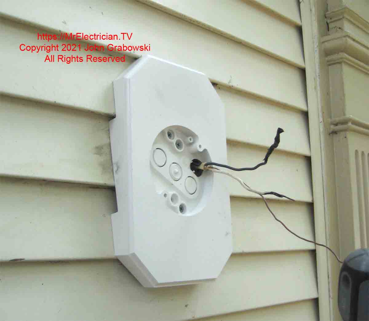 A siding box is used to mount a light fixture on vinyl siding outside.