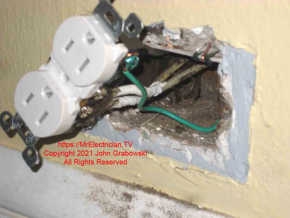 A new three-prong tamper-resistant electrical outlet connected to a grounding clip with a grounding pigtail wire