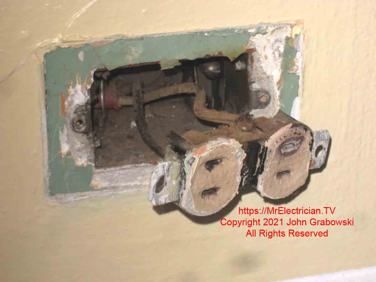 An old two wire electrical outlet in need of replacement