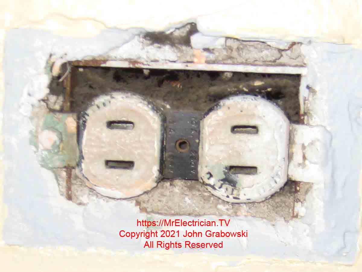 A two-prong ungrounded electrical outlet mounted in the wall