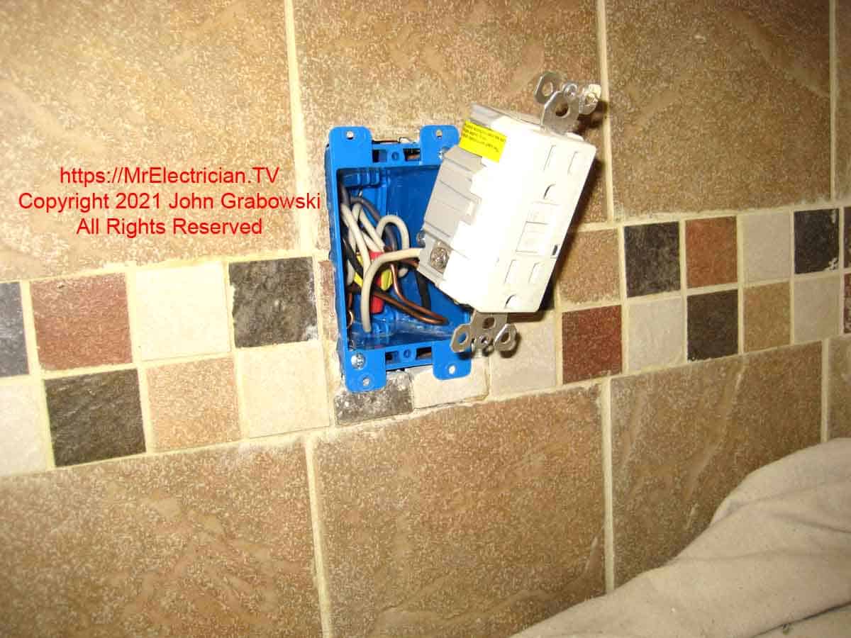 A GFCI outlet connected to wire pigtails in a newly installed outlet box