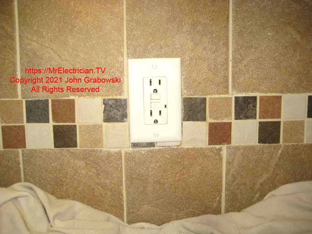 A new GFCI outlet and wall plate installed on a new plastic outlet box that replaced one with a broken screw