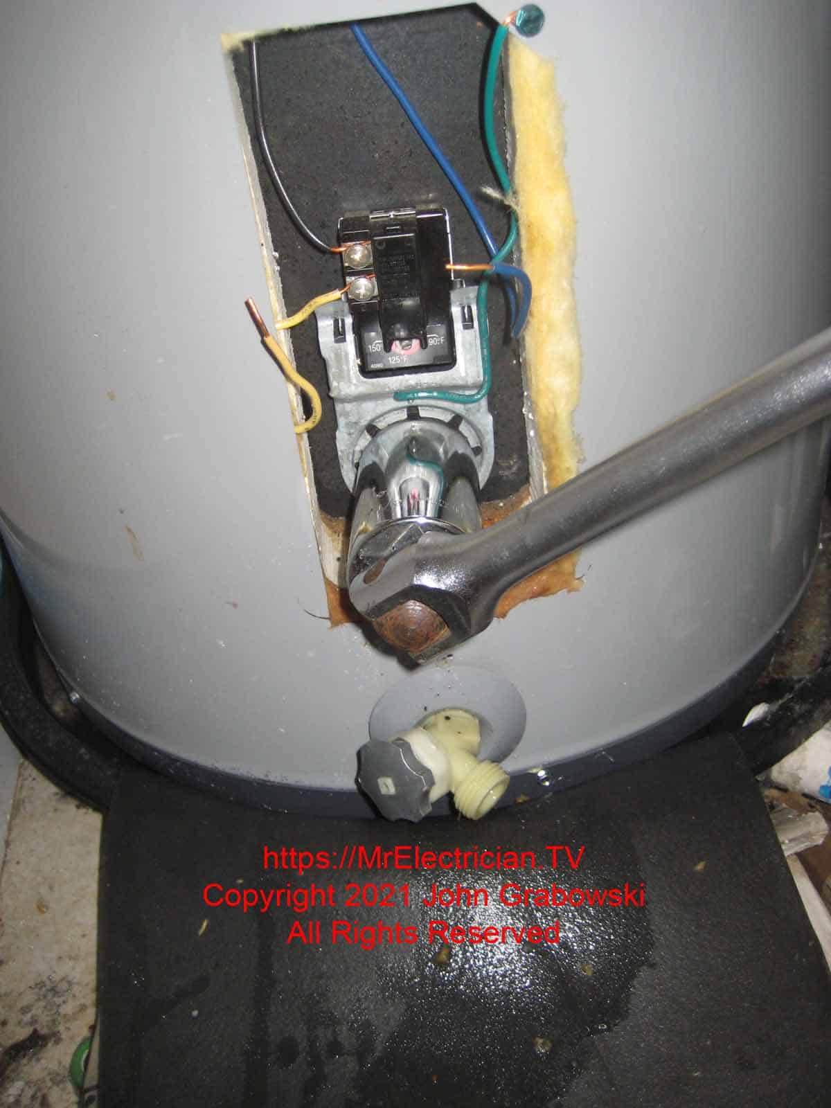 Using a breaker bar and hex socket to remove an electric water heater heating element