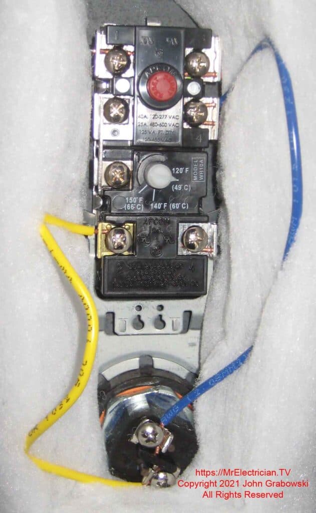 The upper thermostat and heating element of an electric water heater