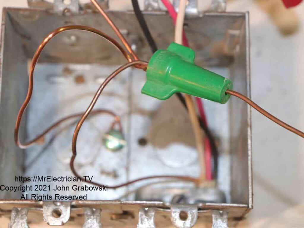 Pigtail wire at each end of the green wire connector for two wiring devices in this metal outlet box