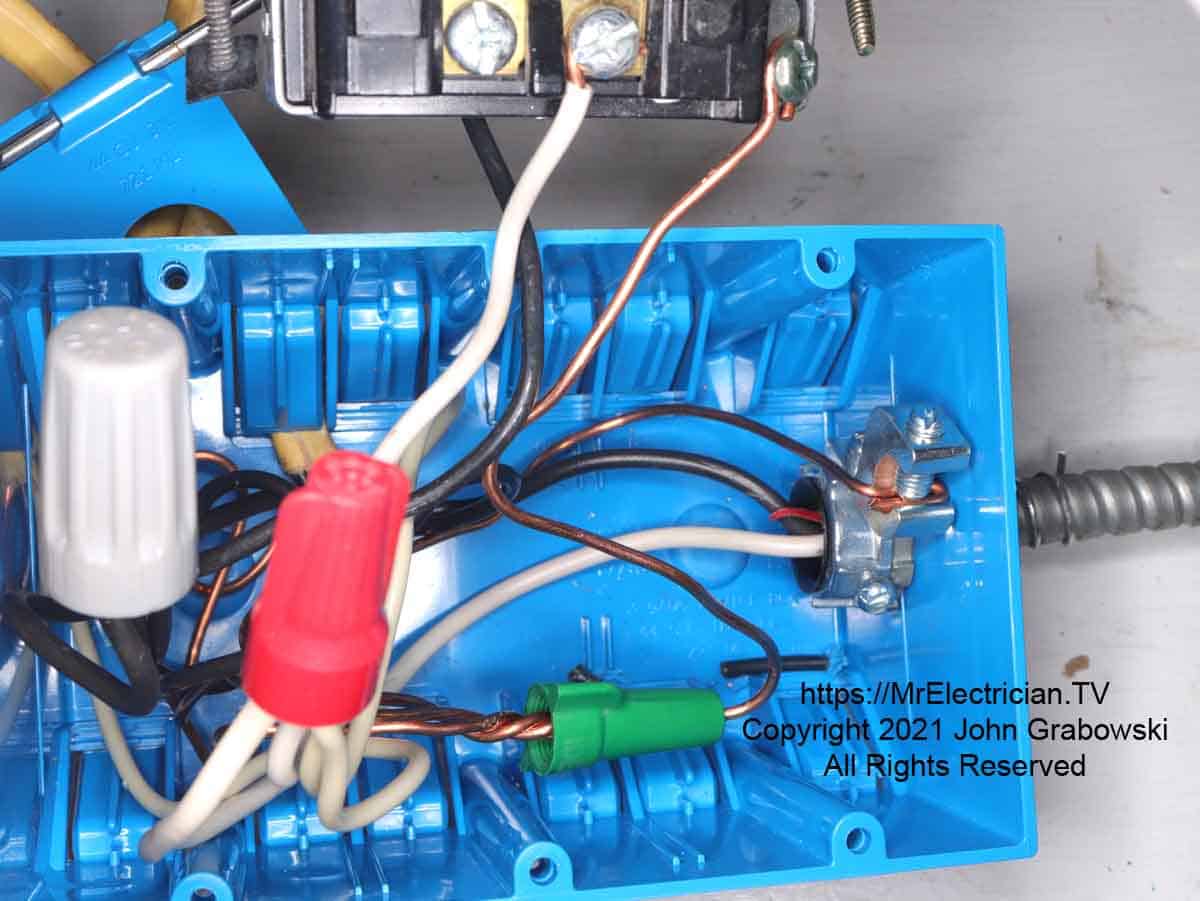 BX cable in a plastic outlet box and a grounding bushing for a ground connection