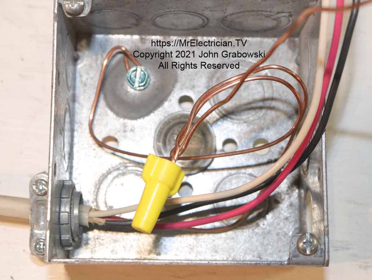 All of the grounding wires in a square electrical box joined with a standard wire connector