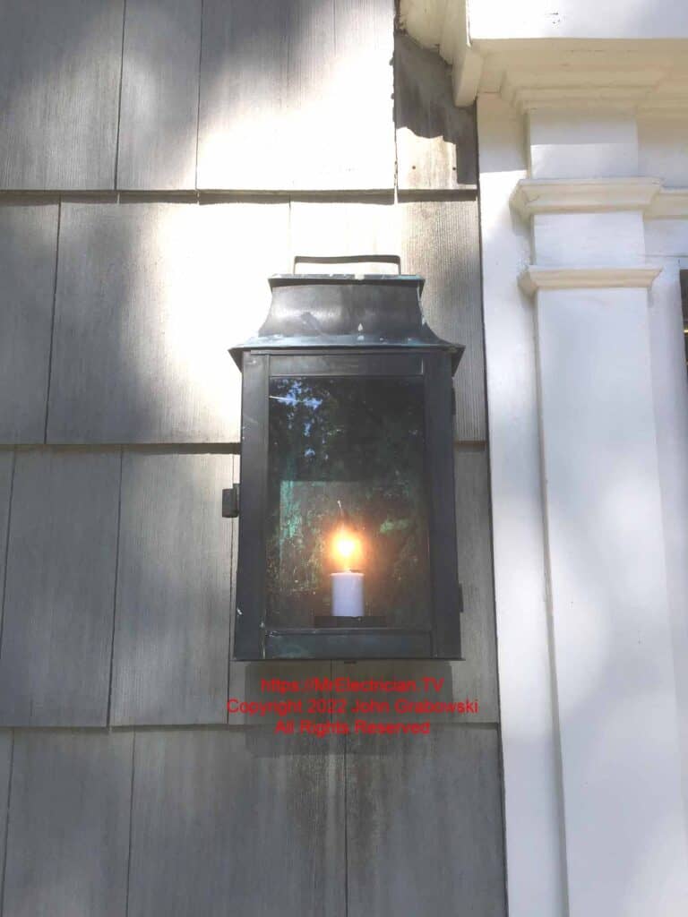 An antique copper electric lantern is mounted outdoors next to the front door.