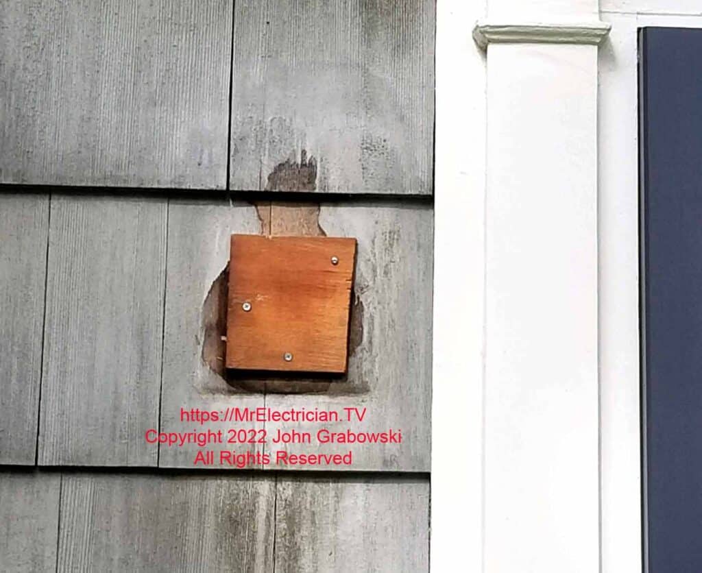 A blanked off hole where an old exterior light fixture used to be
