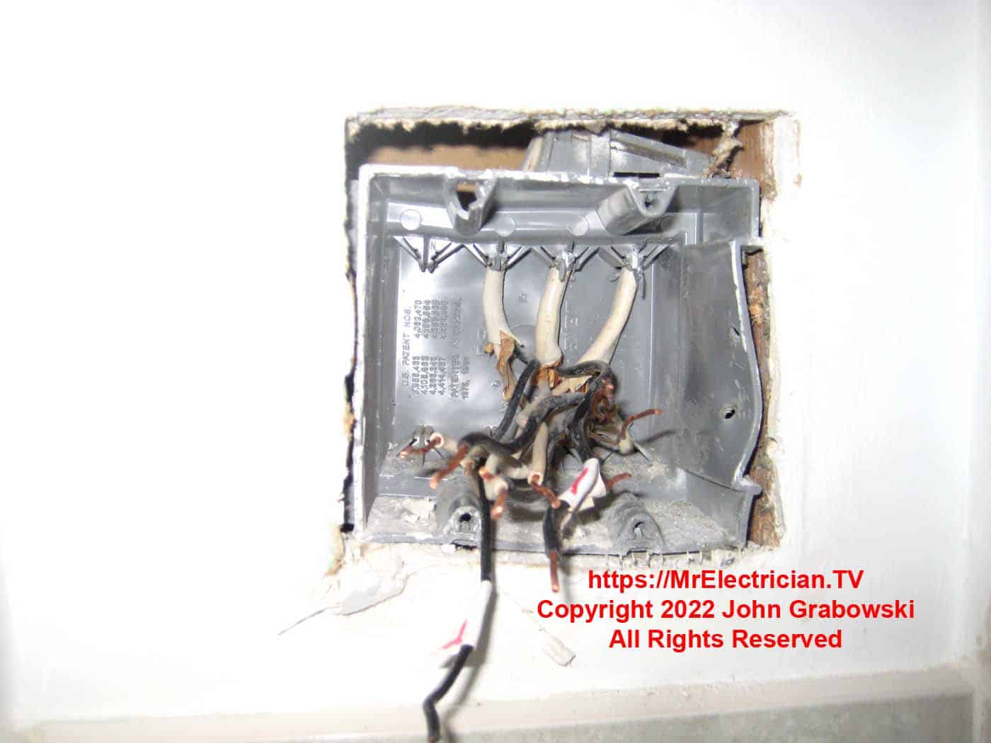 A broken PVC plastic, two gang electrical box wrongly installed in the wall