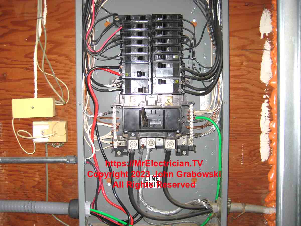 Interior of the electrical panel where a Tesla Electric Vehicle Charger is connected to a circuit breaker. Red and black wires are terminated on the circuit breaker, and the green grounding conductor is terminated on the neutral/ground termination bar.