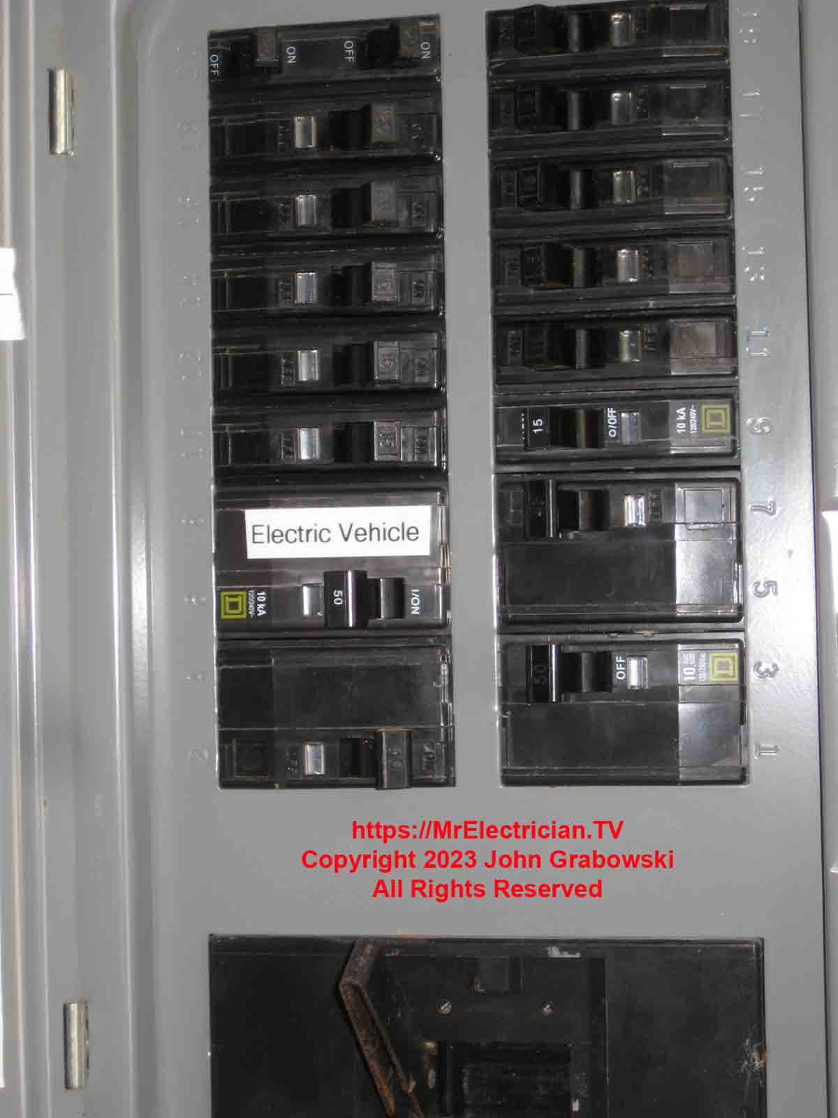 A close shot of the main electrical panel row of circuit breakers with the Tesla EV Charger circuit breaker identified with a P-Touch label.