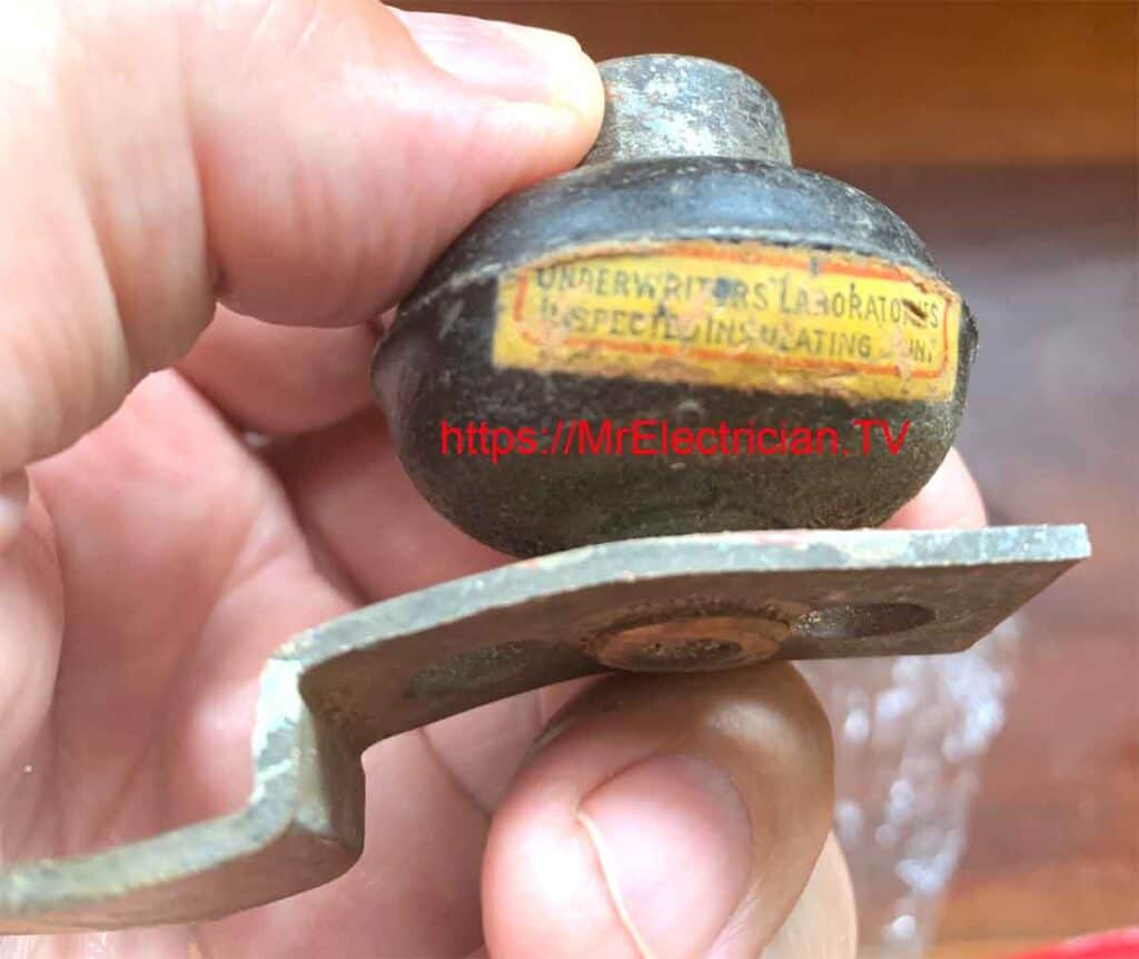 A photo of an old electrical insulator from a 1910 house, with a wall sconce support bracket threaded onto the brass nipple. A photo of an old electrical insulator from a 1910 house, with a wall sconce support bracket threaded onto the brass nipple.