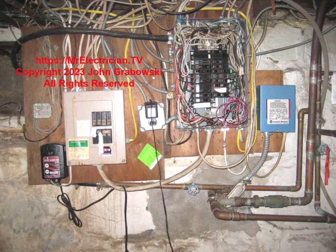 Two old basement electrical sub-panels, one of which is fed from the other