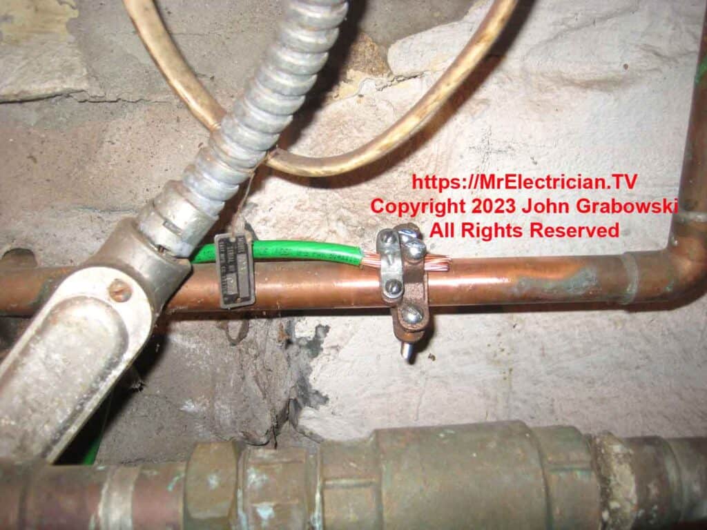 A water pipe ground connection using a water pipe ground clamp and number 4 green copper wire