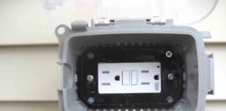 A surface mounted electrical receptacle outlet with the bubble cover lifted up to reveal the weather resistant GFCI.