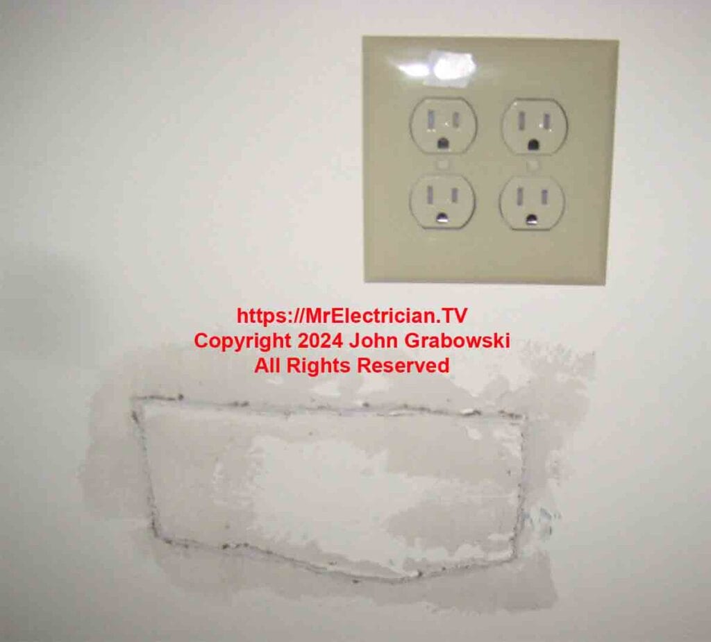 A two gang electrical outlet installation with with the access hole patched below.