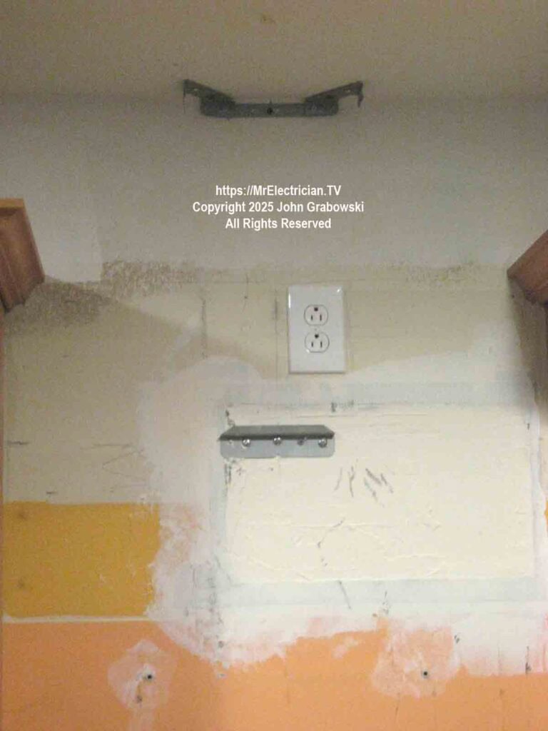 An electrical outlet and brackets on the wall over the stove ready for a chimney hood installation An electrical outlet and brackets on the wall over the stove ready for a chimney hood installation
